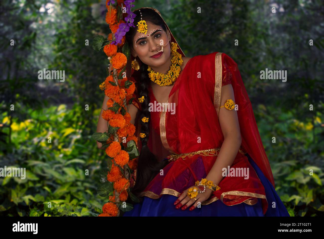 Young woman dressed up as Radha and sitting on a swing on the occasion of Janmashtami Stock Photo