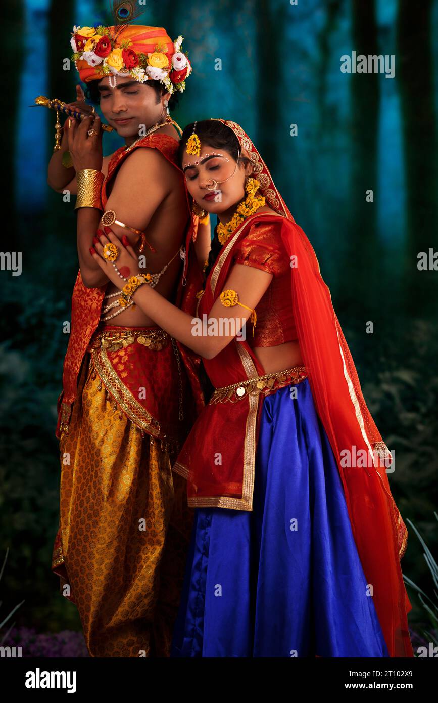 Young man and woman dressed up as Radha and Krishna and romancing on