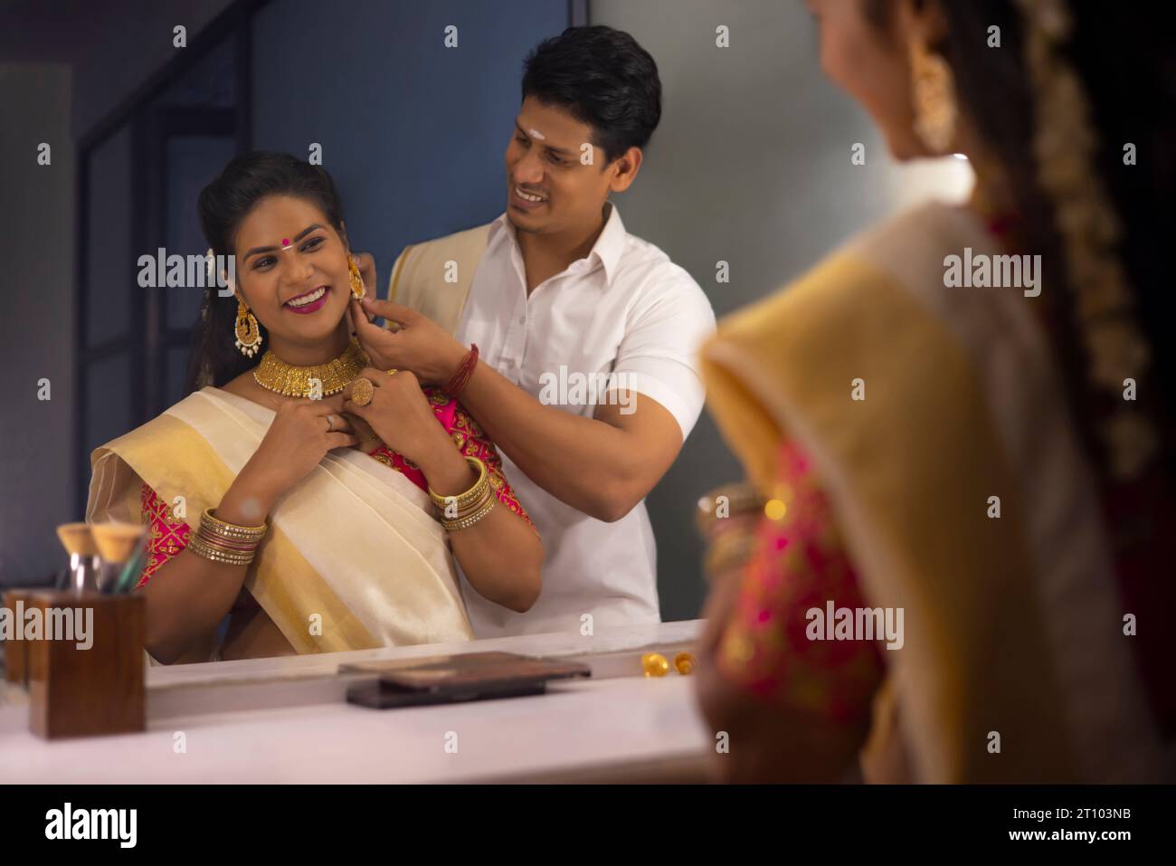 Husband helping his wife to get ready on Onam Stock Photo