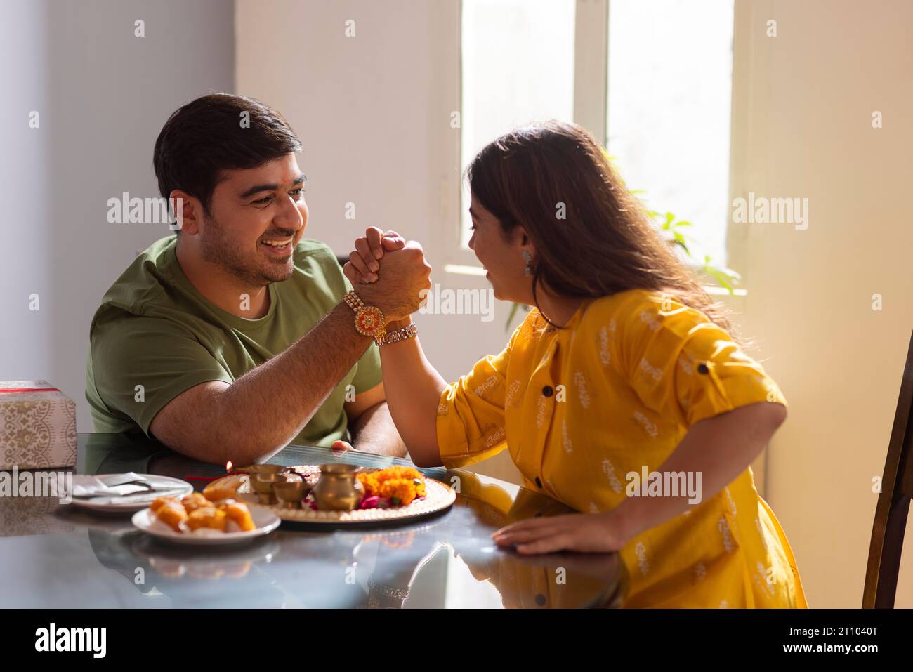 Sibling arm wrestling while celebrating Raksha Bandhan Stock Photo