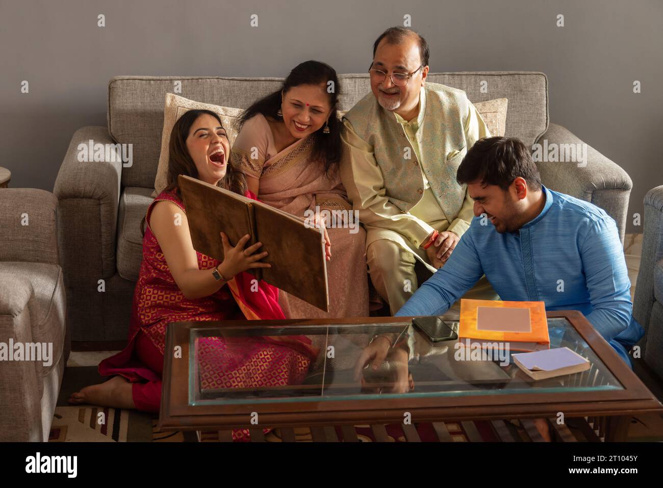 Happy Indian family watching photo album together at home Stock Photo