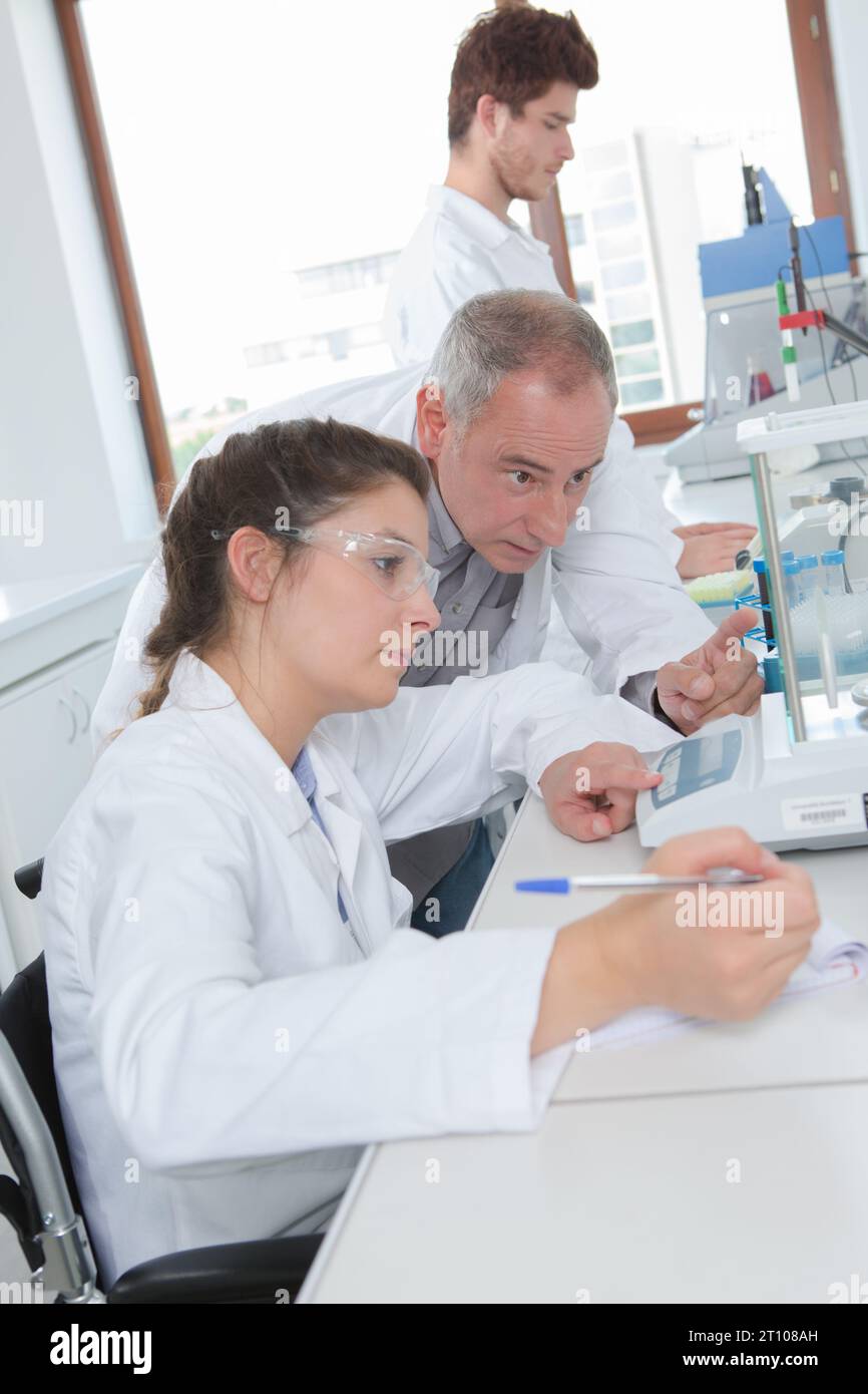 student on a wheelchair in a chemistry lab Stock Photo