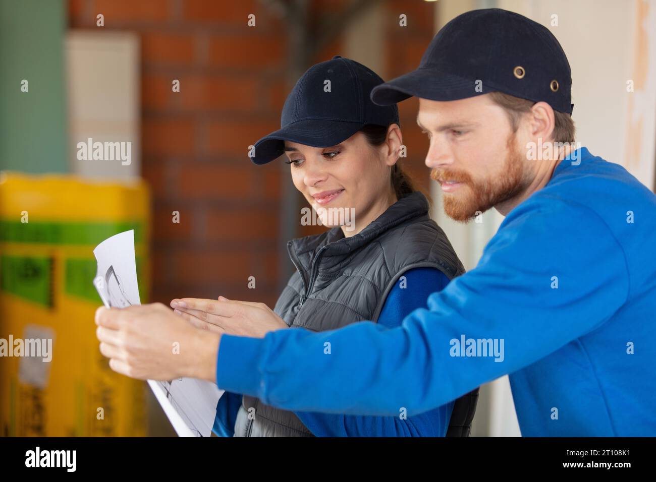 construction young workers look at home plans Stock Photo