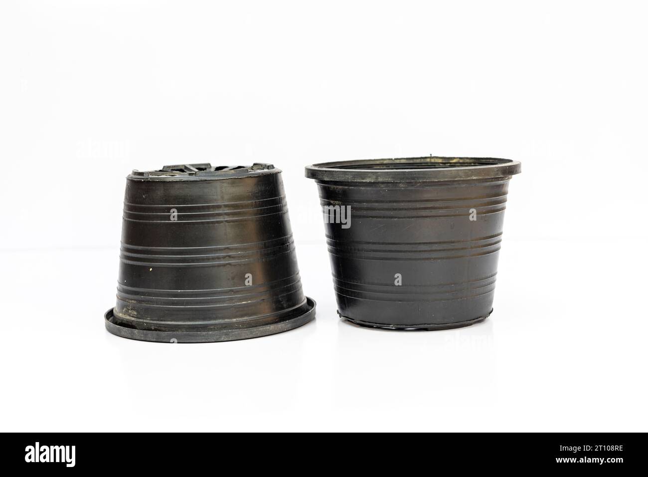 Black nursery pots for plants upside down with drainage holes isolated