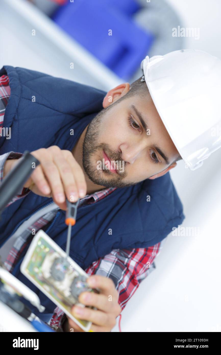 engineer working on circuit board with screw driverc Stock Photo