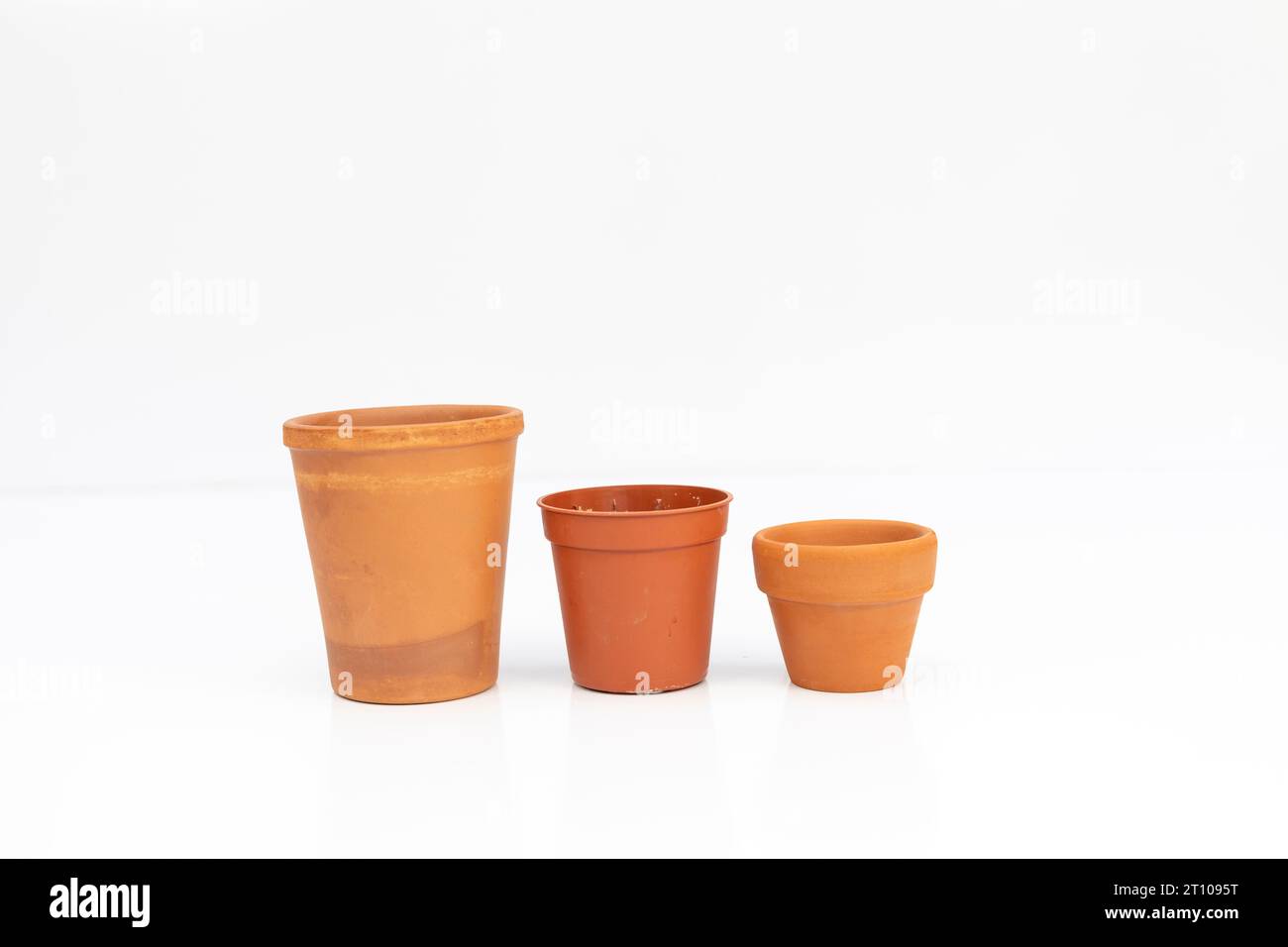 Row of empty terracotta plant pots in different sizes and shapes isolated on white background Stock Photo