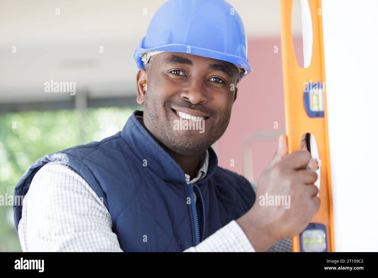 mixed-race construction worker using a spirit level Stock Photo