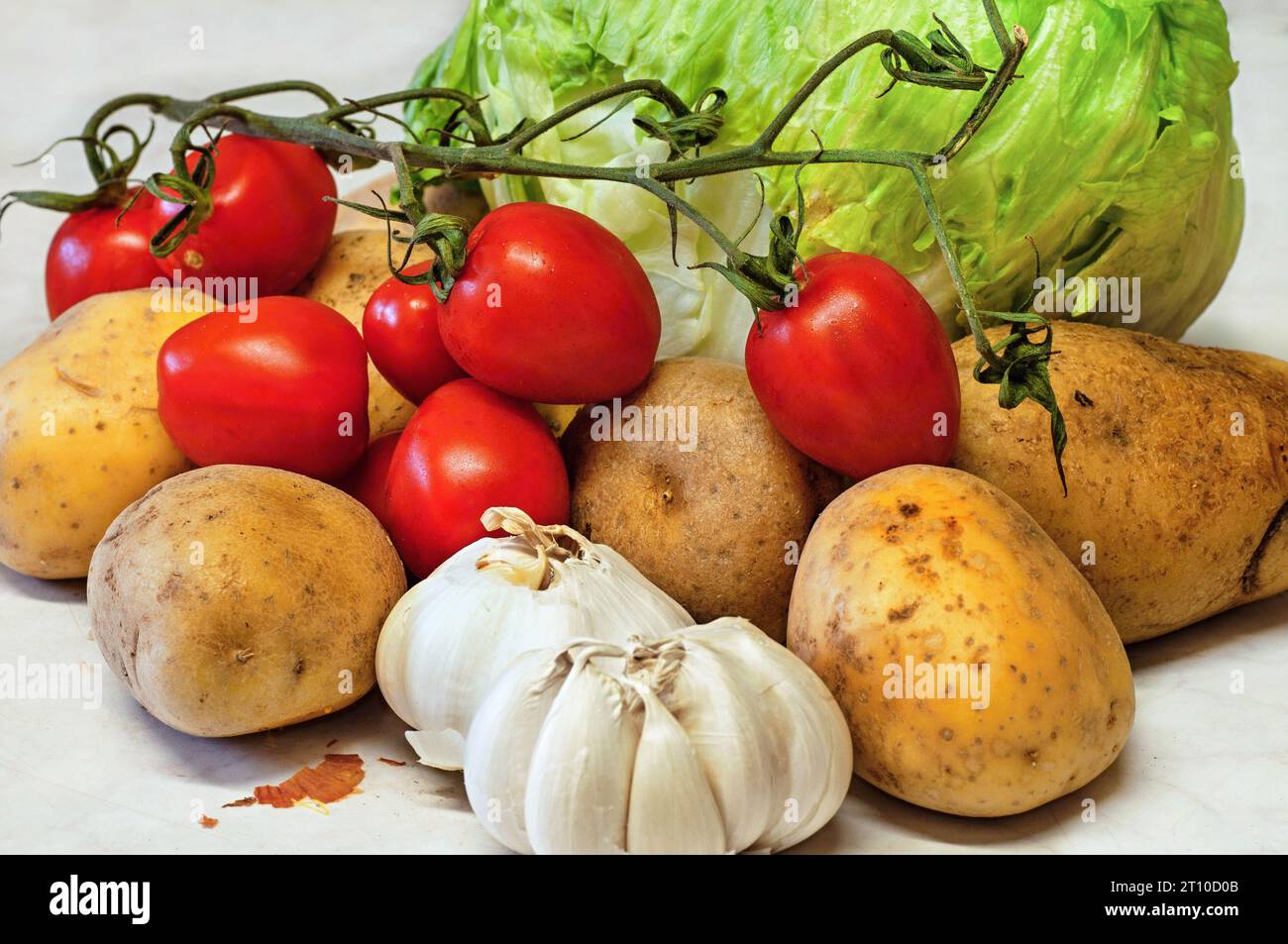 Mix of fresh vegetable - garlic, potato, tomato and lettuce, closeup. Stock Photo