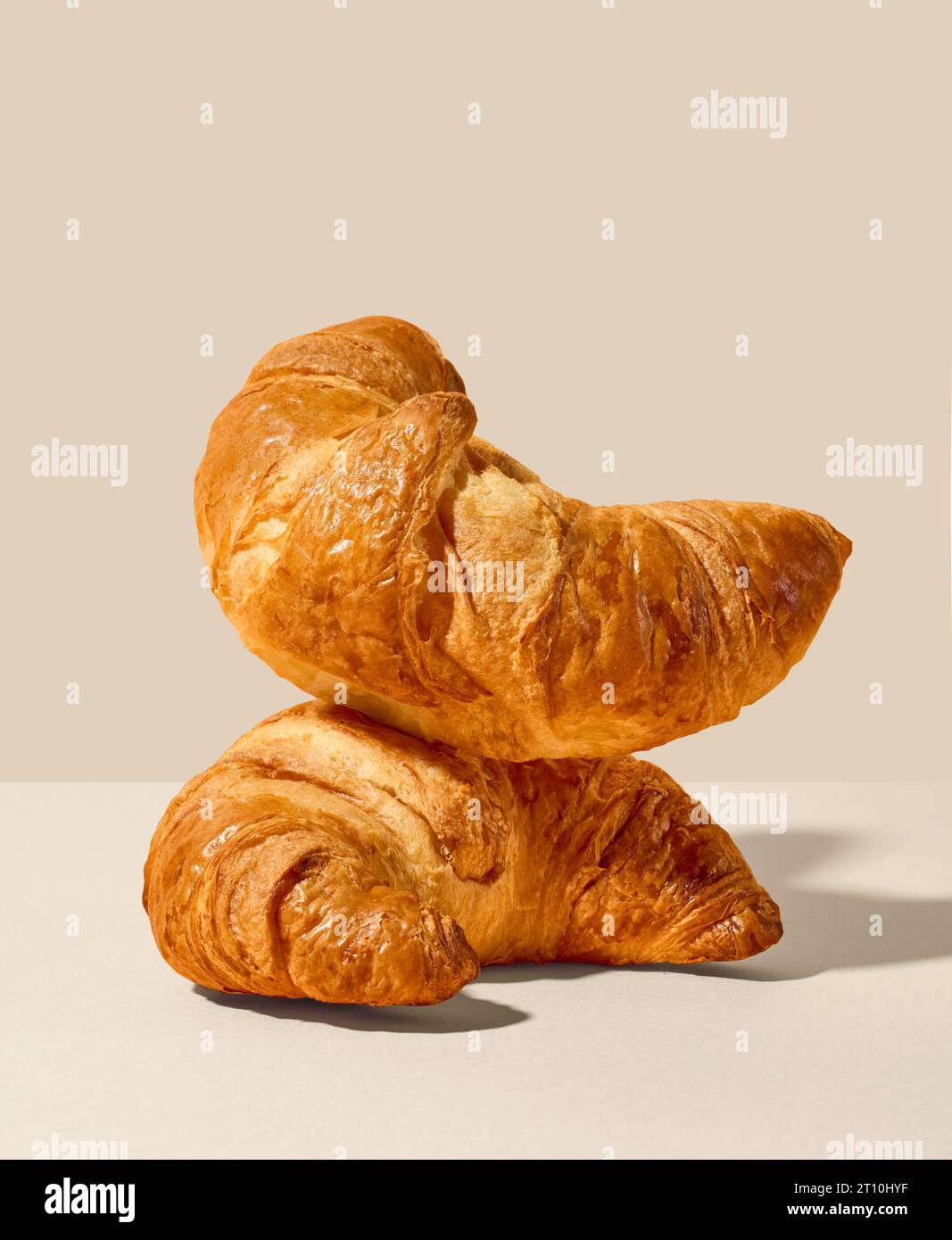 stack of freshly baked croissants on beige background Stock Photo