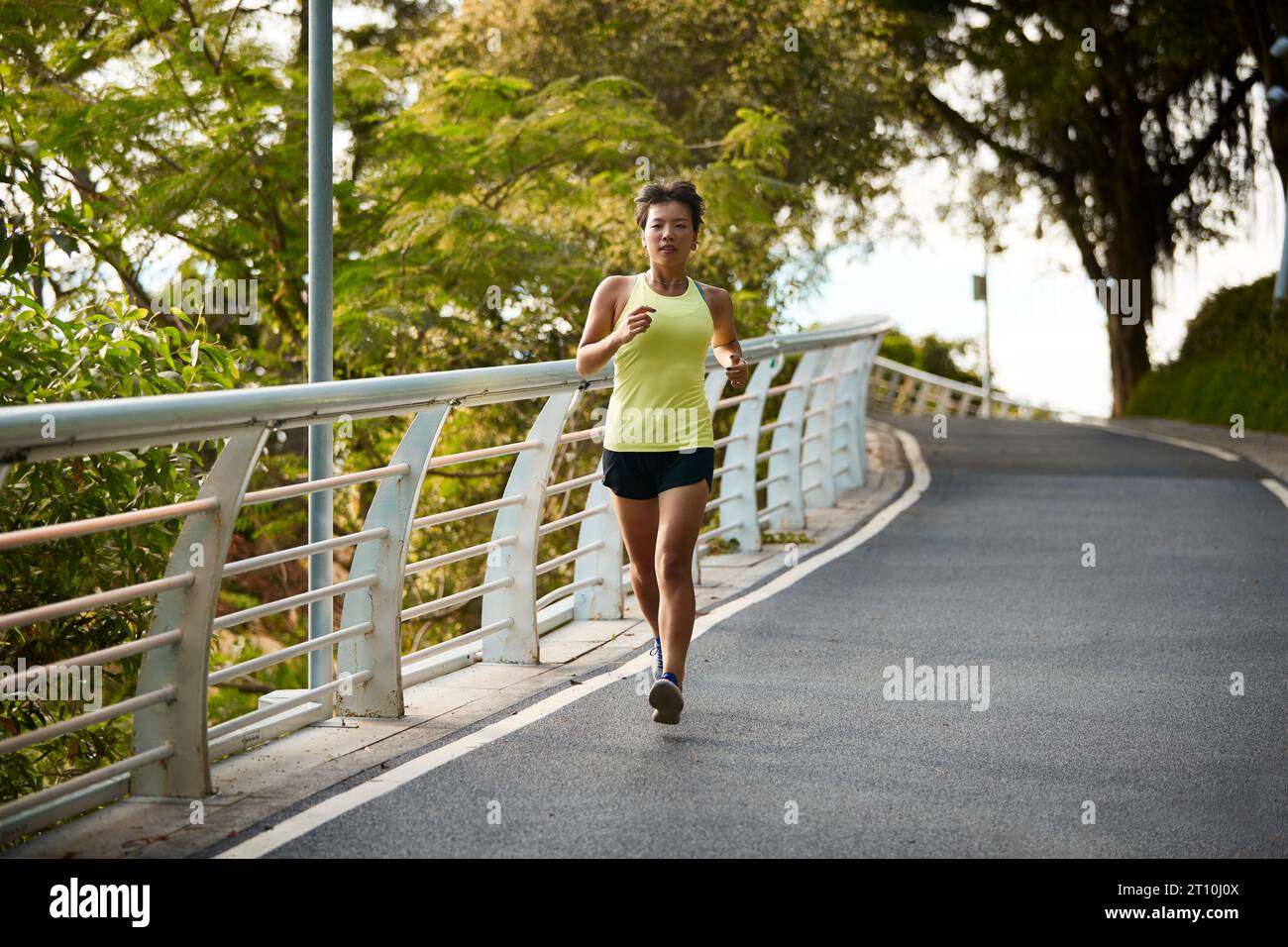 young asian woman female jogger exercising outdoors in city park Stock Photo