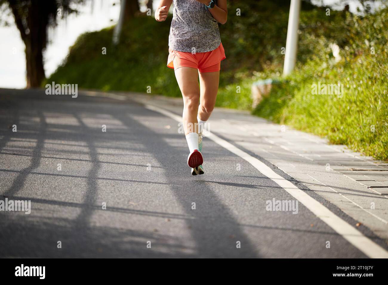 young asian woman female jogger exercising outdoors in city park Stock Photo