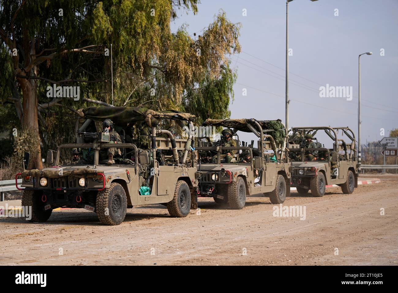 Israeli soldiers drive by the rave party site, where scores were killed ...