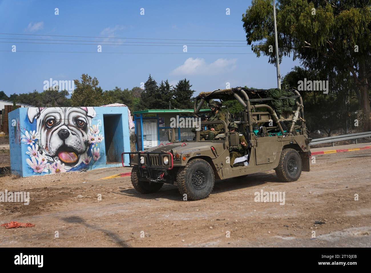 Israeli soldiers drive by the rave party site, where scores were killed ...