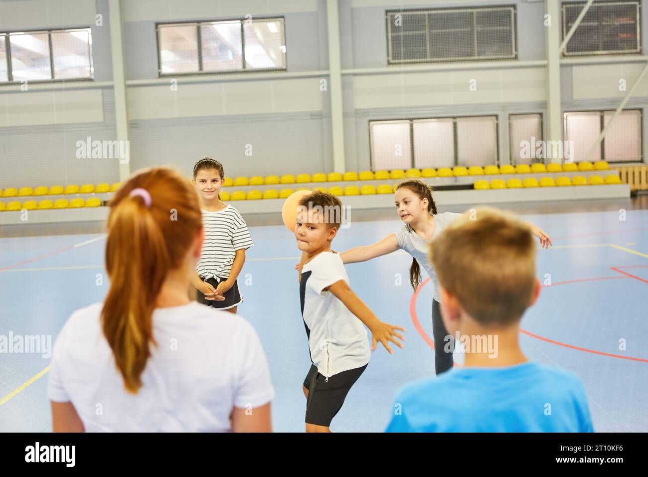 Schoolboy throwing ball on friends during gym class in school Stock Photo Alamy