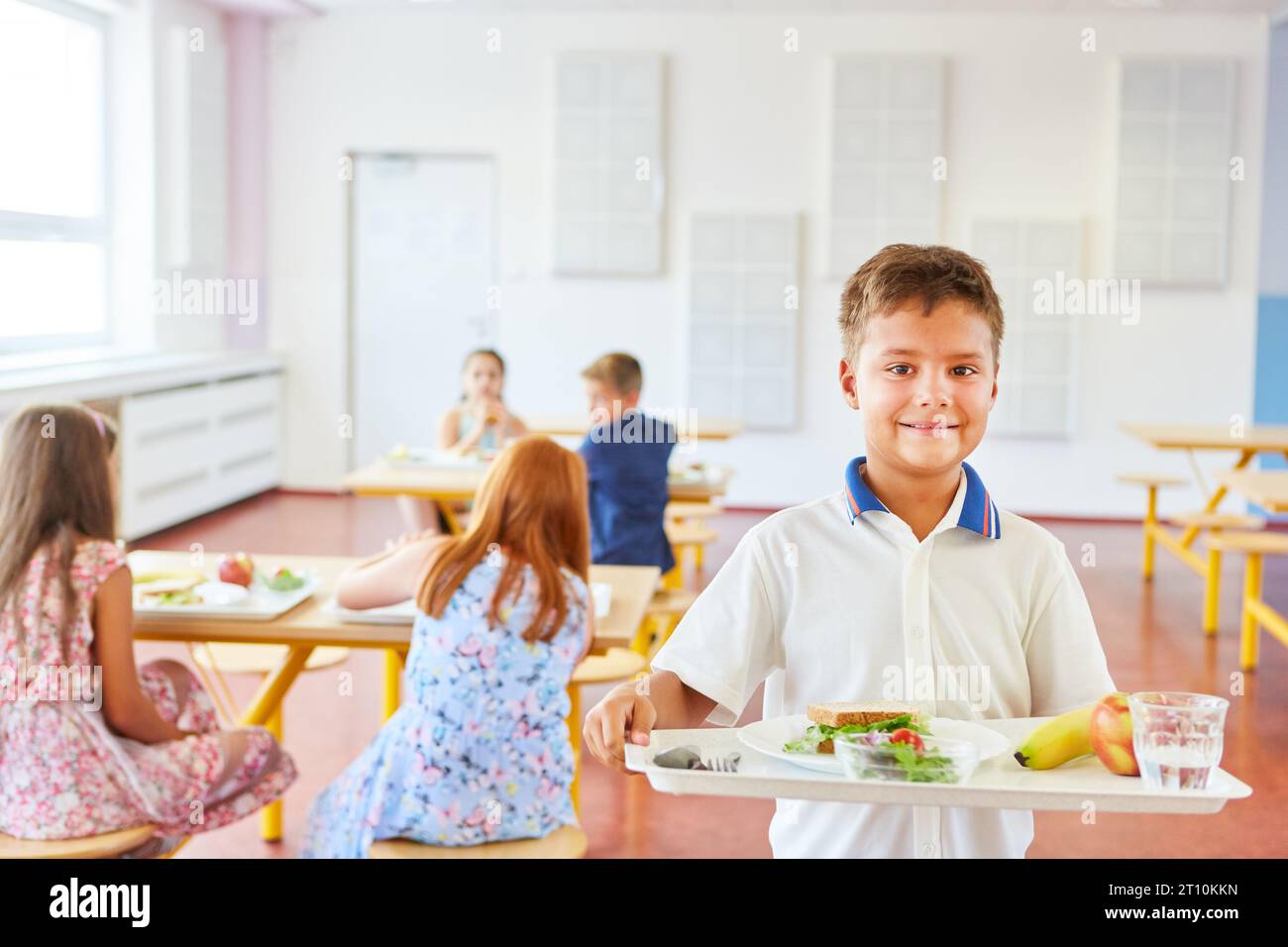 Multiracial kids sitting at table in school canteen and greeting newcomer  boy holding tray with food. Children s relationships concept. Vector  illustration for banner, website, poster, advertisement. Stock Vector