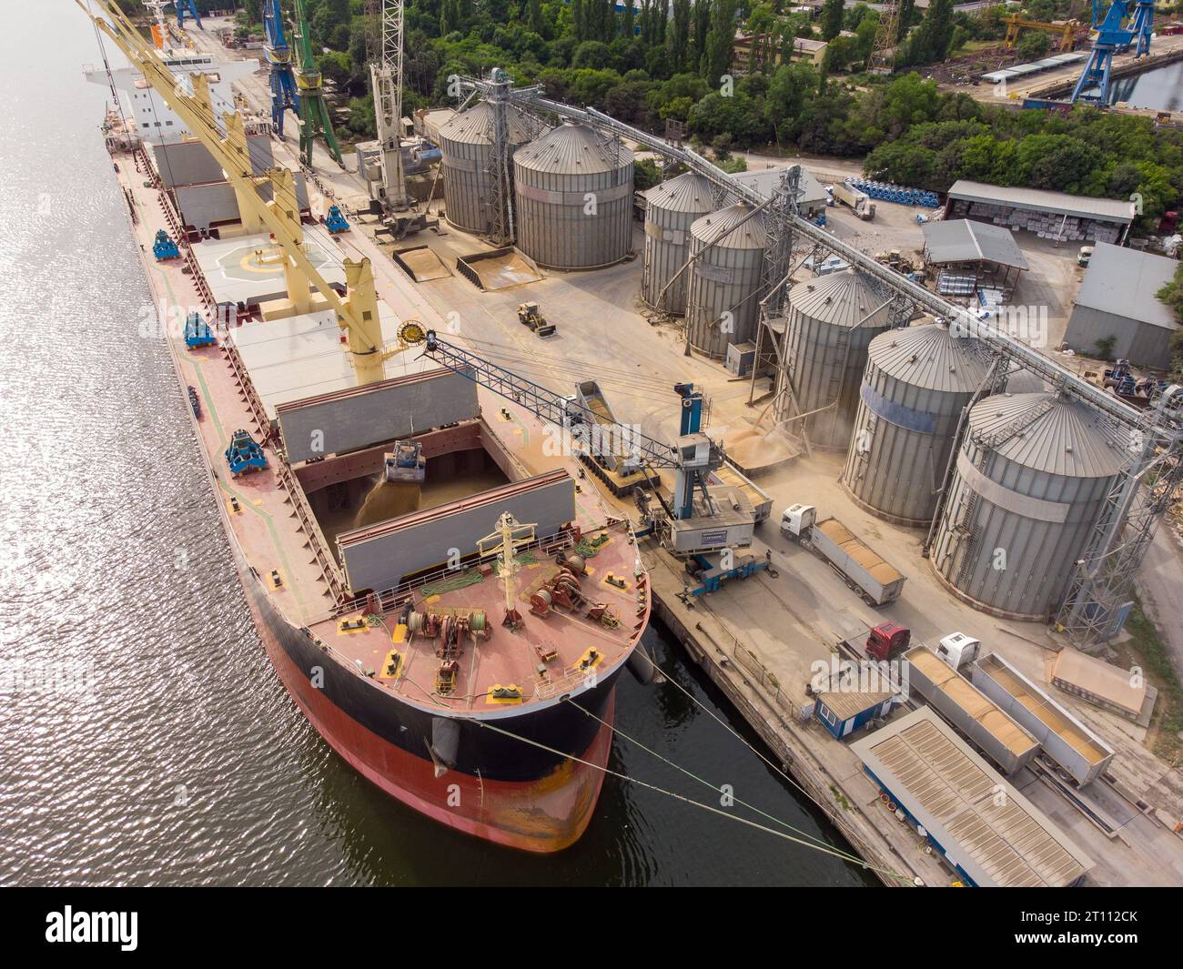 Loading grain into holds of sea cargo vessel in seaport from silos of