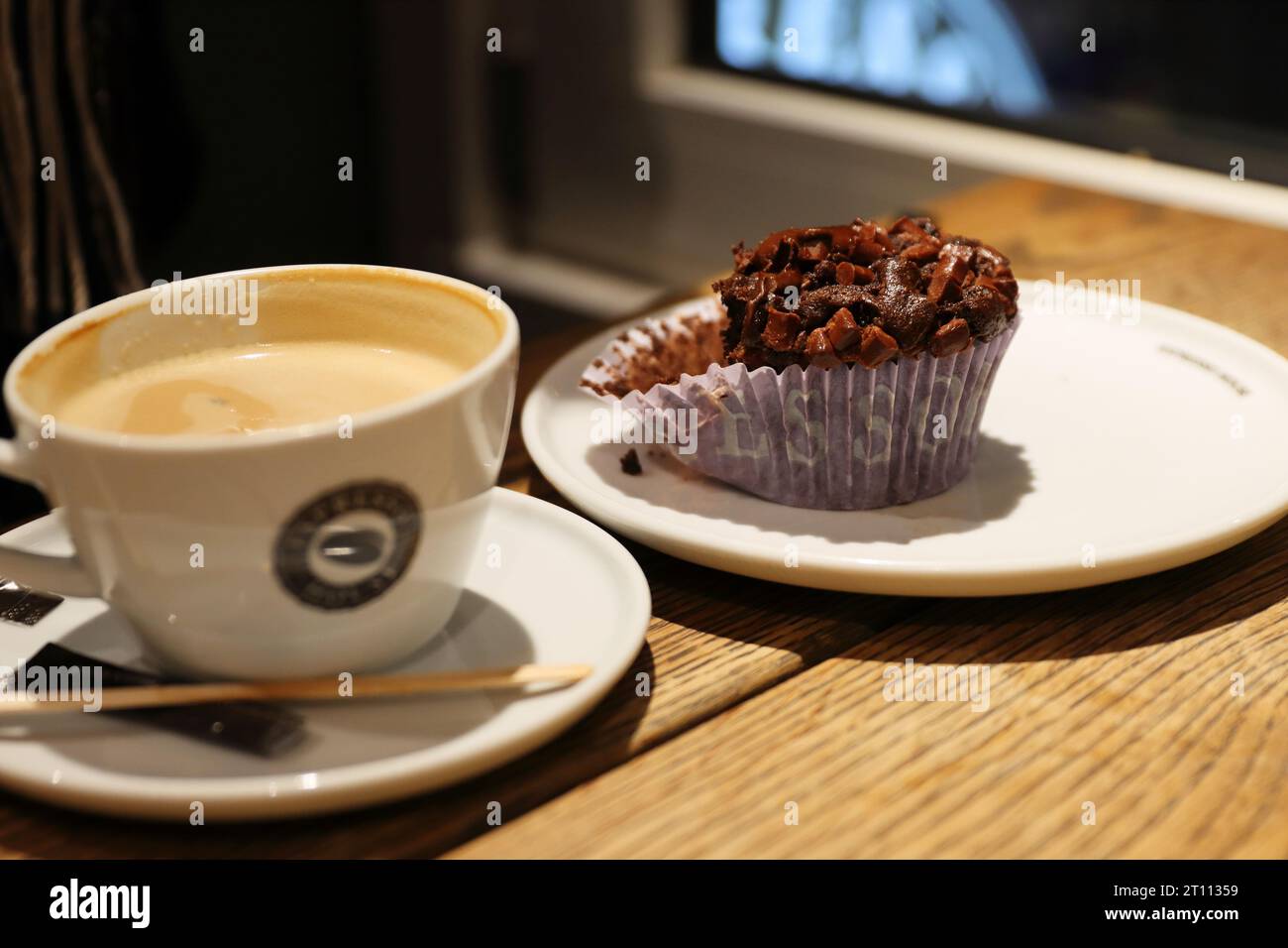 Copenhagen, Denmark - February, 20th, 2023. Espresso House. A cup of cappuccino with milk foam and delicious homemade chocolate cupcake on the vintage Stock Photo