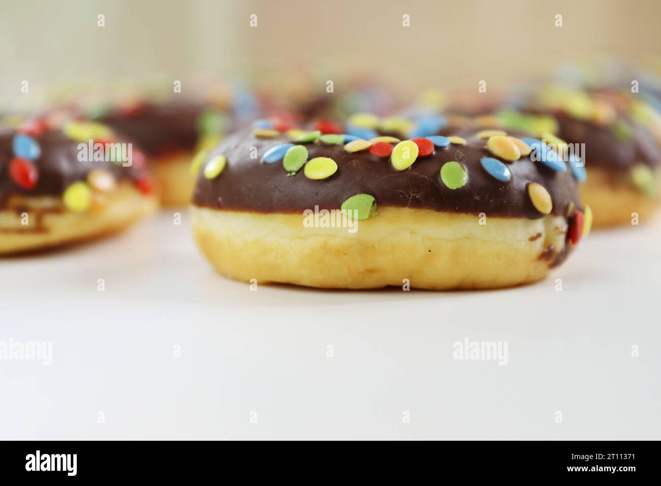 Chocolate doughnut decorated with colorful smarties isolated