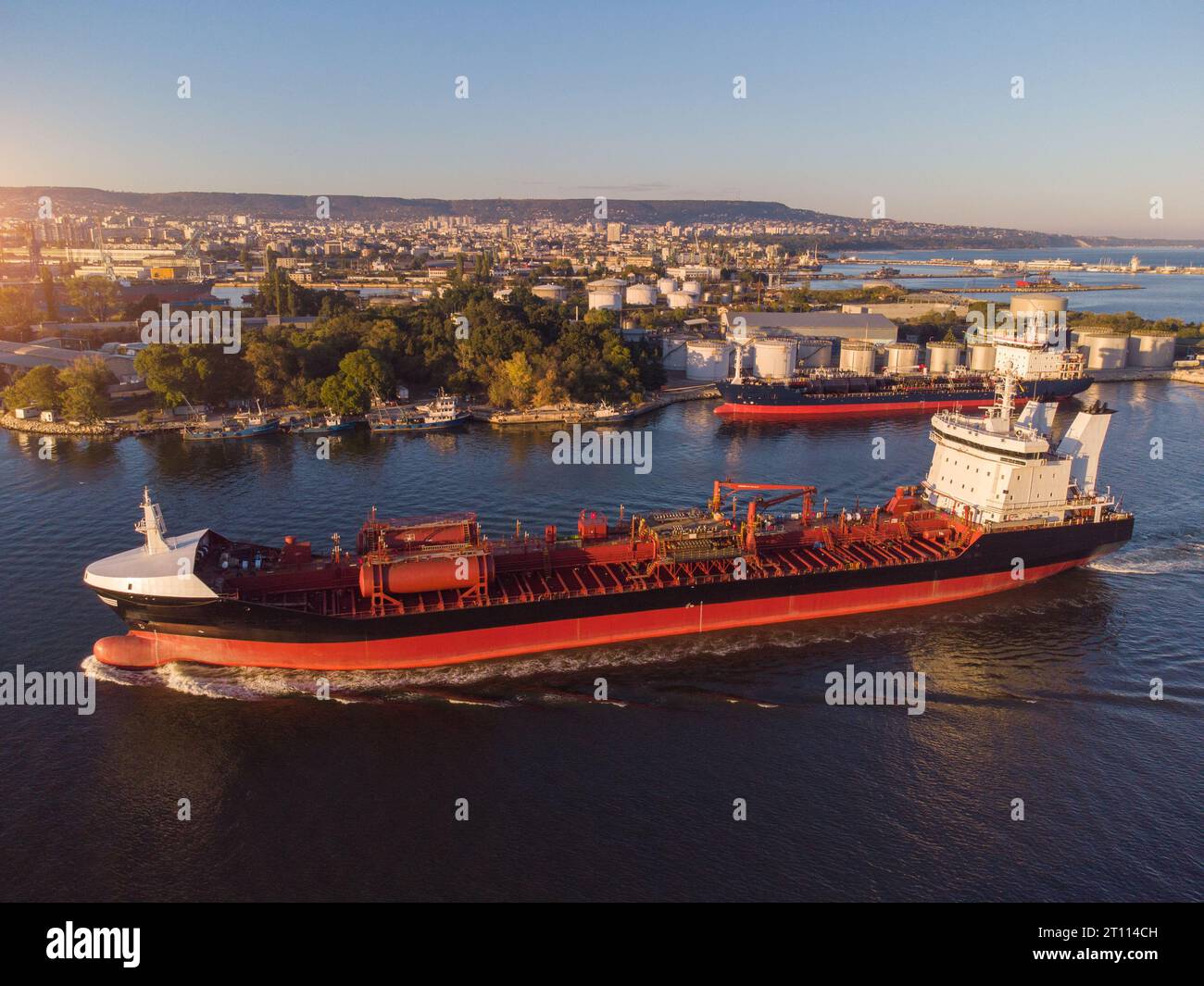 Aerial view of Chemical industry storage tank and tanker ship entering to the oil terminal, drone video Stock Photo