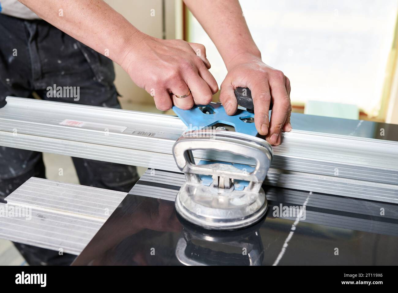 Construction worker cutting ceramic tiles using ceramic cutter Stock Photo
