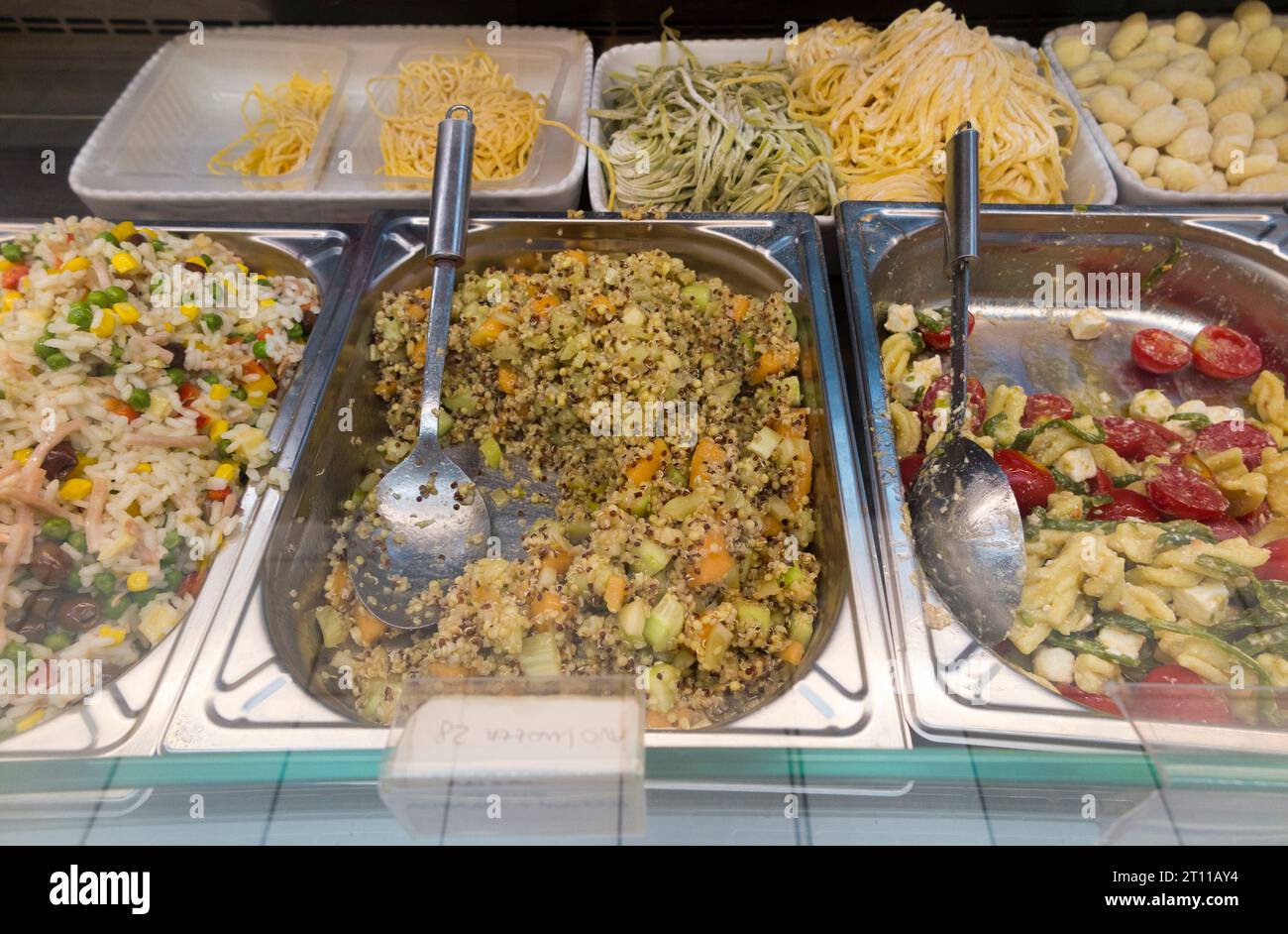 Fresh pasta, rice and mild salad, tomato, coleslaw etc., for sale by weight in chilled foods cabinet / food fridge aisle in a mini supermarket. (135) Stock Photo