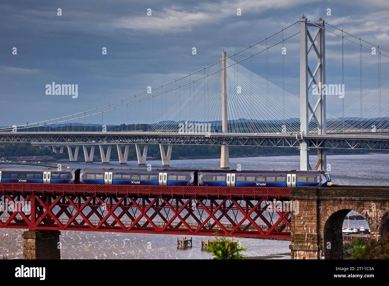 Scotrail diesel train crossing Forth Rail Bridge with Forth Road Bridge and Queensferry Crossing in background, North Queensferry, Fife, Scotland, UK Stock Photo