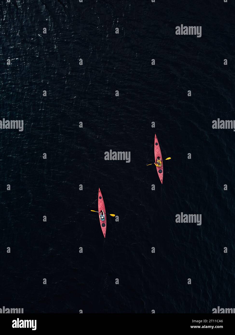 aerial view of two red kayaks in dark blue lake water. Drone photo Stock Photo