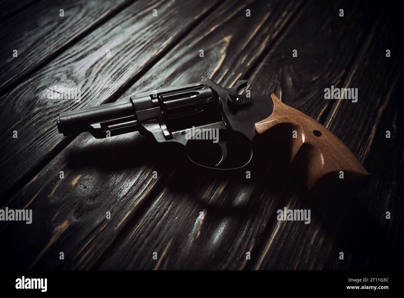 Black revolver pistol on dark wooden background Stock Photo
