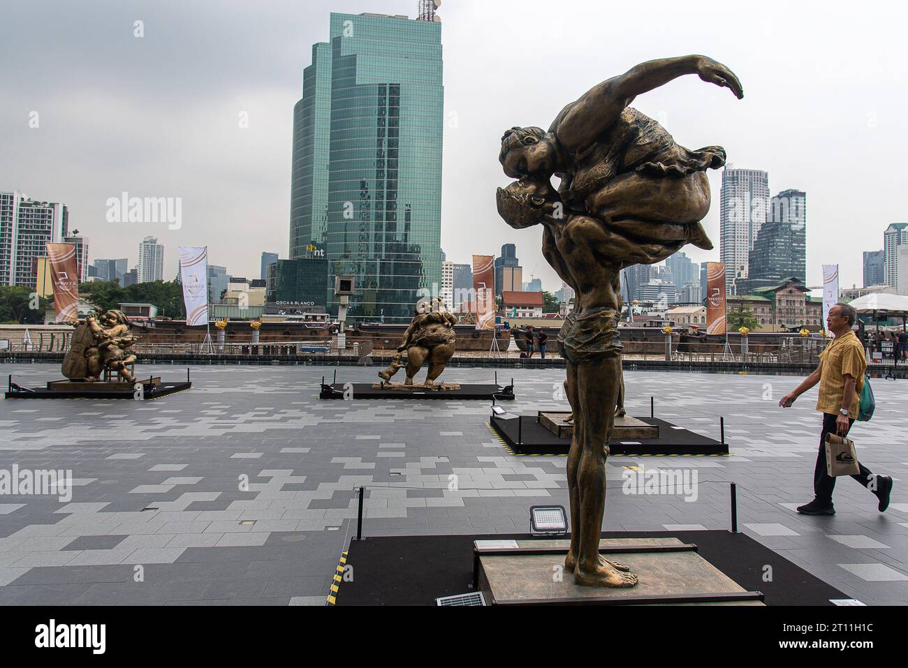 Bangkok, Thailand. 10th Oct, 2023. A visitor walks past sculptures created by Chinese artist Xu Hongfei outside Iconsiam the shopping mall. An exhibition 'Xu Hongfei Sculpture World Tour Exhibition - Thailand: Love in Siam' was held at Iconsiam the shopping mall displayed sculptures created by Chinese artist Xu Hongfei presenting happiness, humor and relationship between Thailand and China. (Photo by Peerapon Boonyakiat/SOPA Images/Sipa USA) Credit: Sipa USA/Alamy Live News Stock Photo