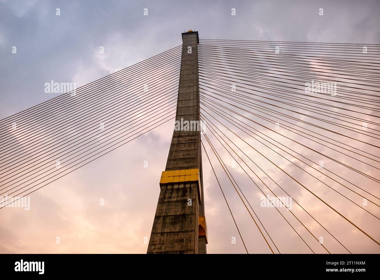 Against a backdrop of cloudy skies, a colossal concrete pylon from a