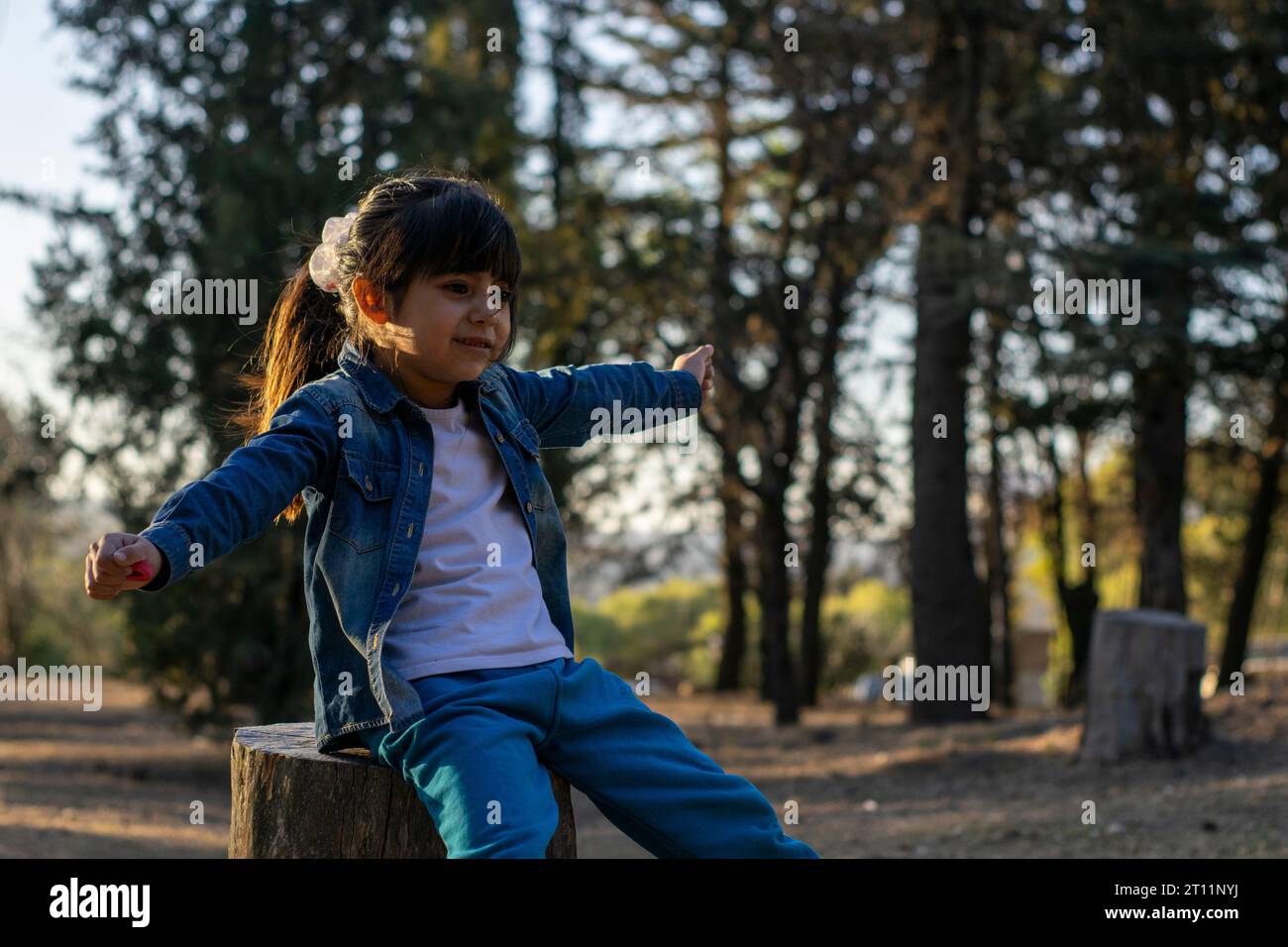 Happy little girl playing in the forest. Stock Photo