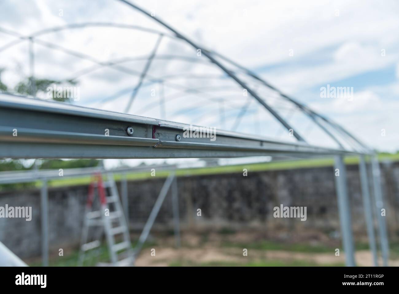 Worker installing screw the Channel Wire Lock to greenhouse Stock Photo Alamy