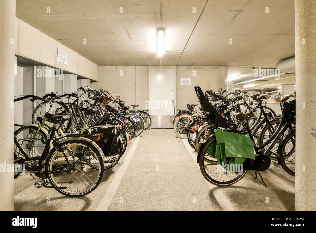 several bikes parked in a parking space with no one on the ground, and there is an open area for them to use Stock Photo