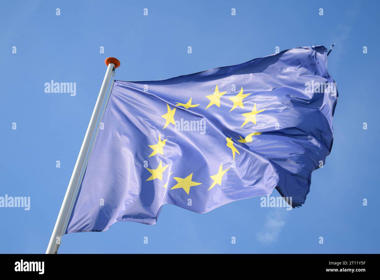 Flag of the European Union on a windy day against a blue sky. Stock Photo