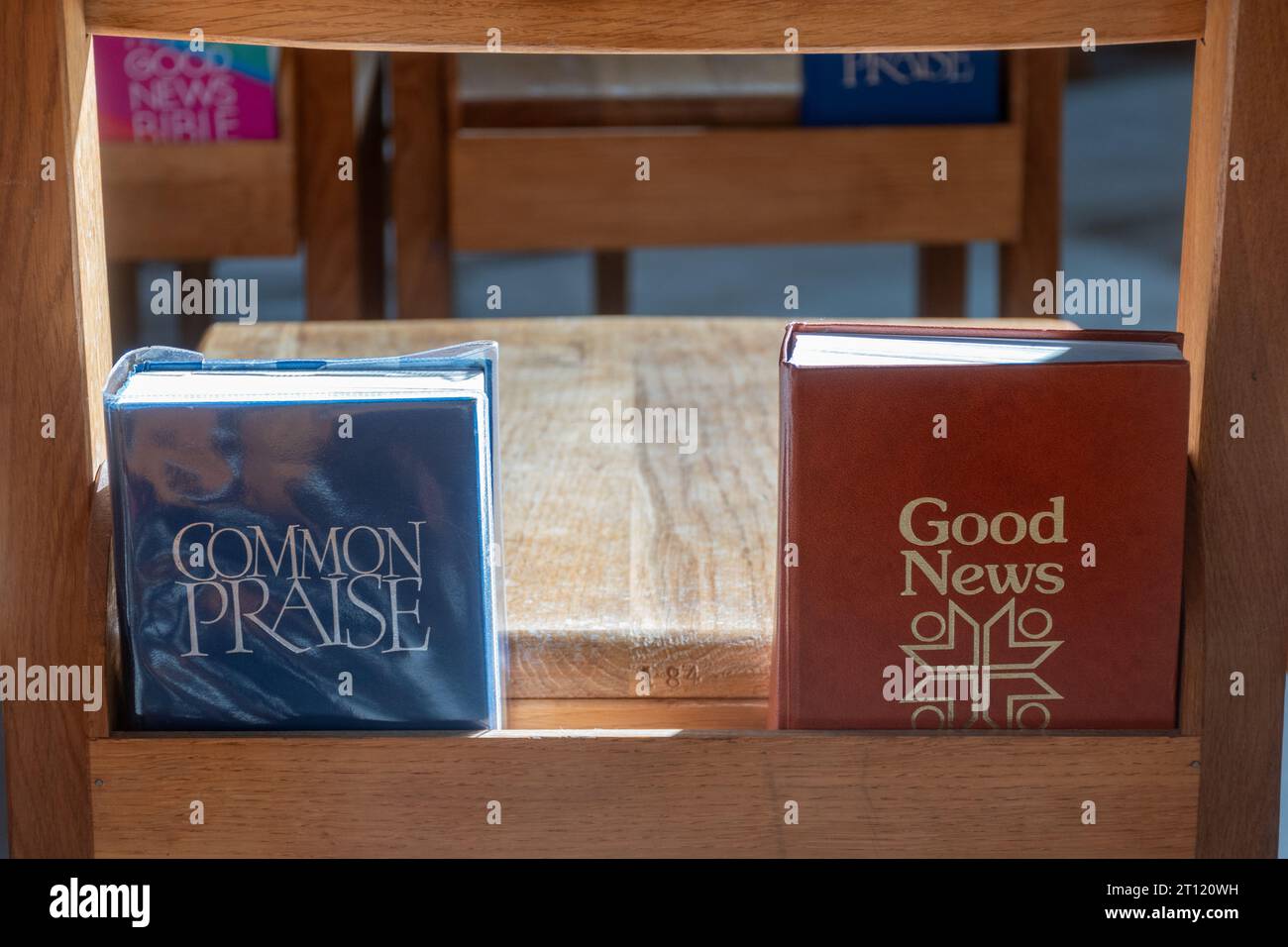 Common Praise hymn book and Good News Bible on church pews, UK Stock Photo
