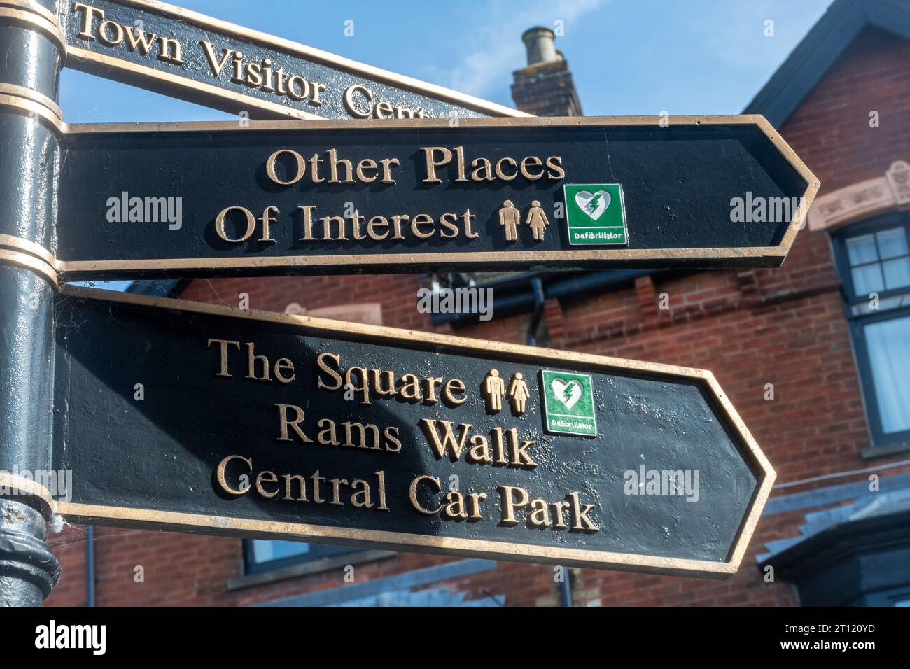 Street signs pointing to places of interest and to positions of defibrillators, England, UK. Sign to defibrillator Stock Photo