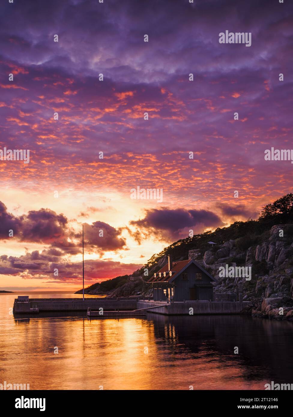 A tranquil waterfront house at vibrant sunset in Sweden. Stock Photo