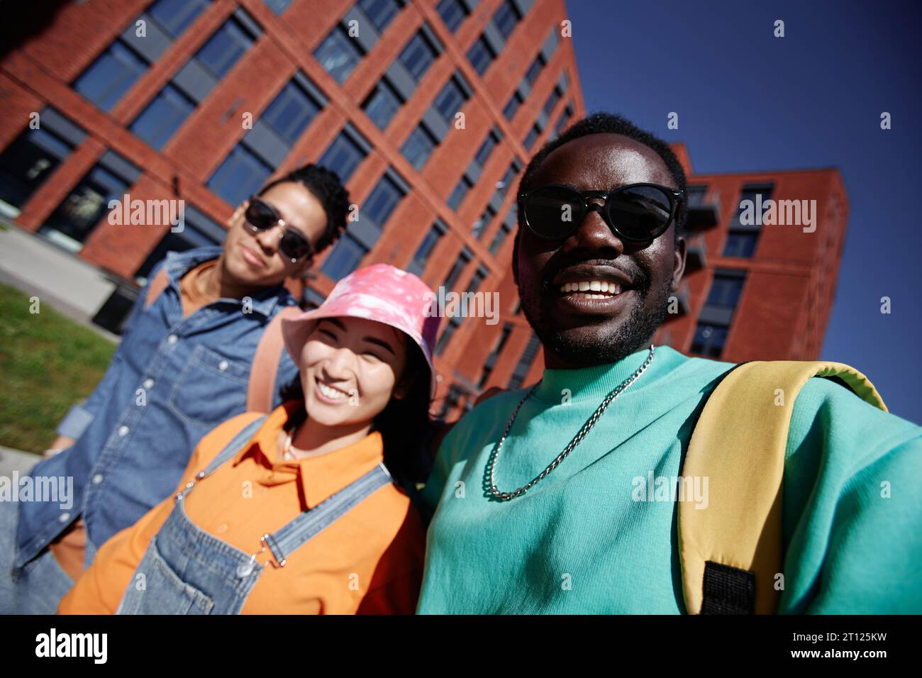 POV of three diverse young students taking selfie photo while walking
