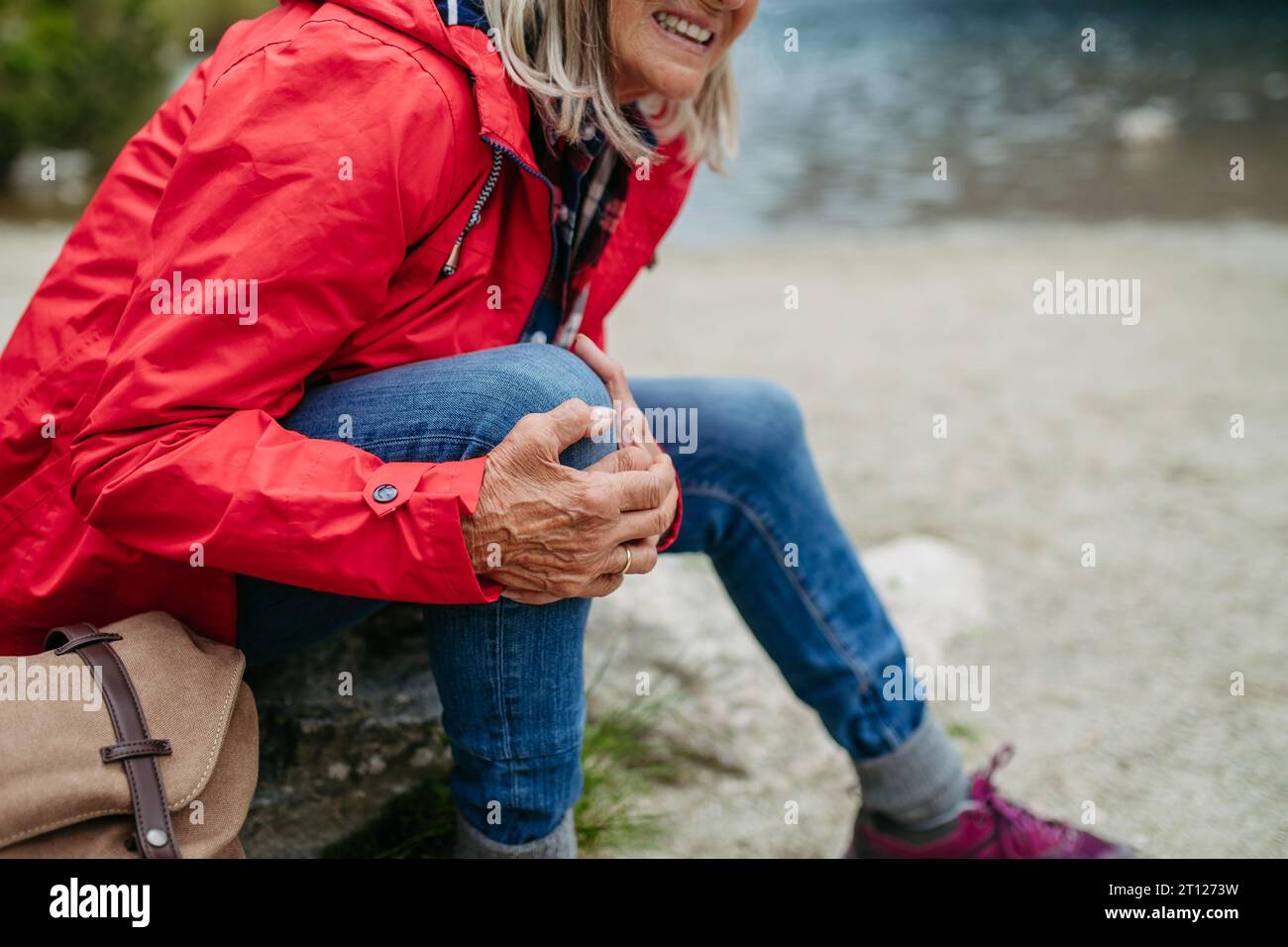 Senior woman injured leg during hike in the mountains. Tourist went off