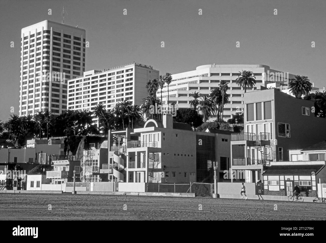 Jogger on bike path with beacfront homes and downtown Santa Monica in background,Los Angeles, California, USA Stock Photo