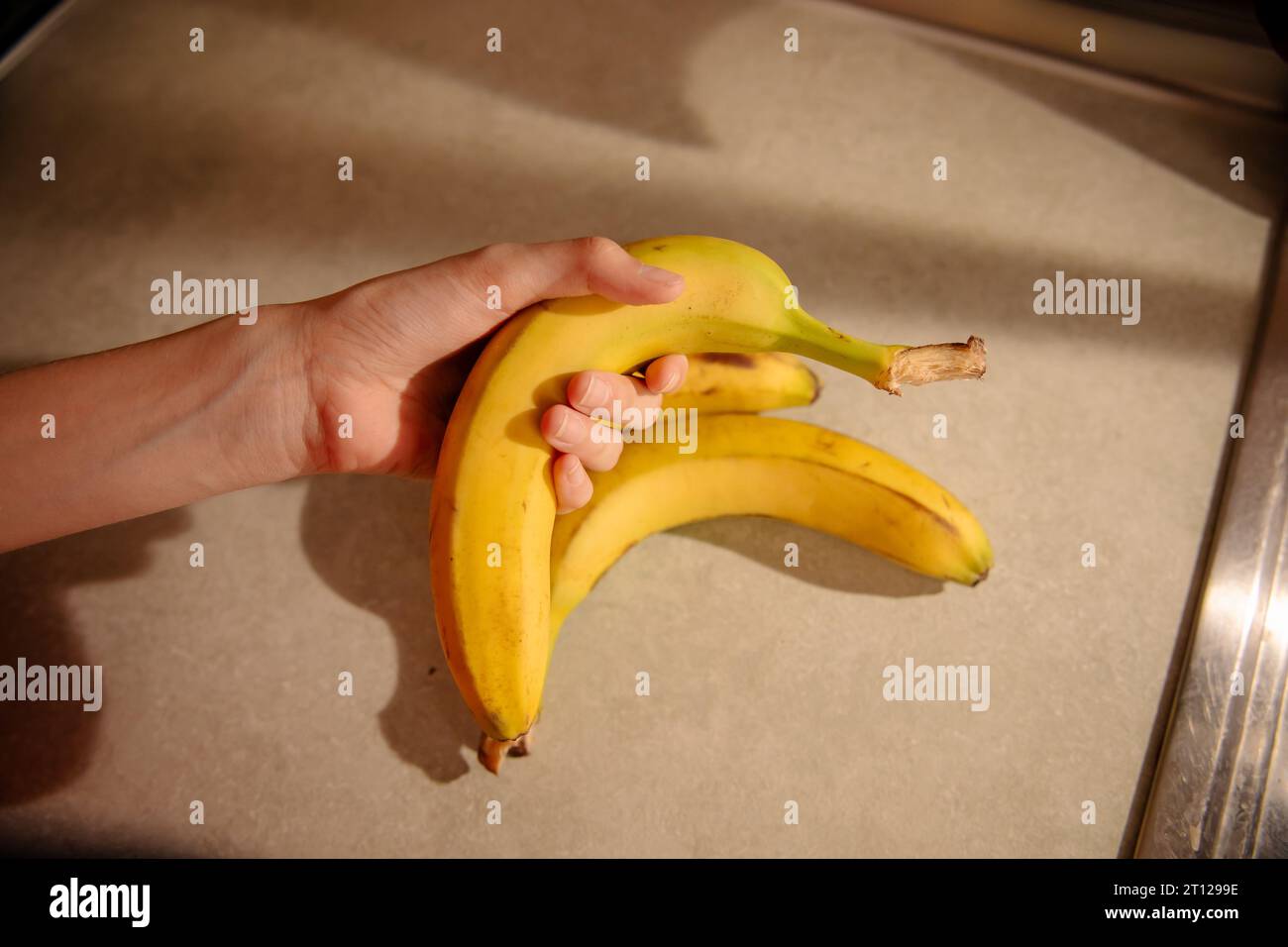 Banana in Female Hand Stock Photo - Alamy