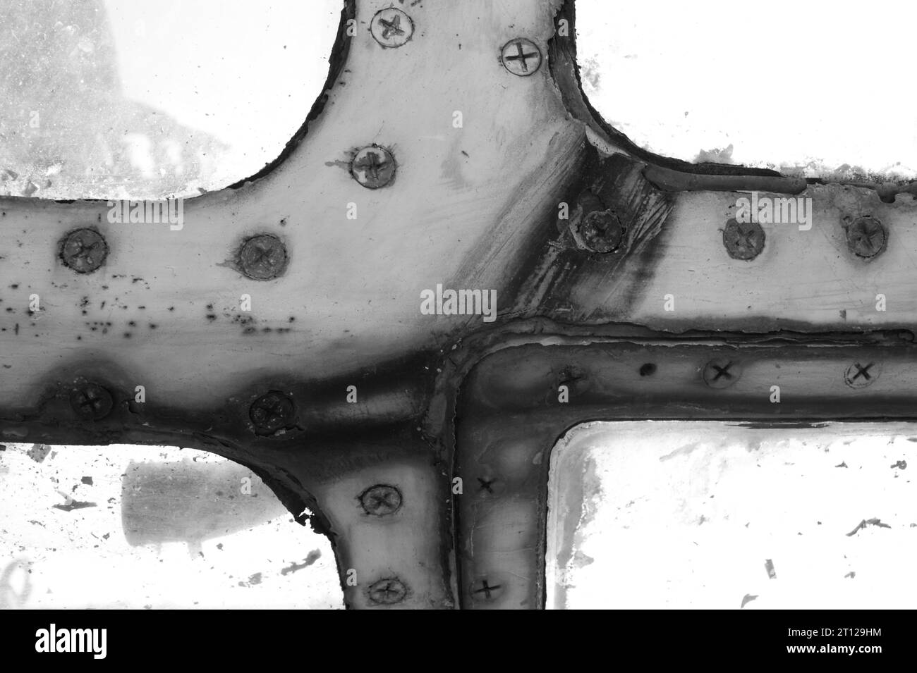 Rusty window frame of an old airplane with screws. Black and white photo. Stock Photo