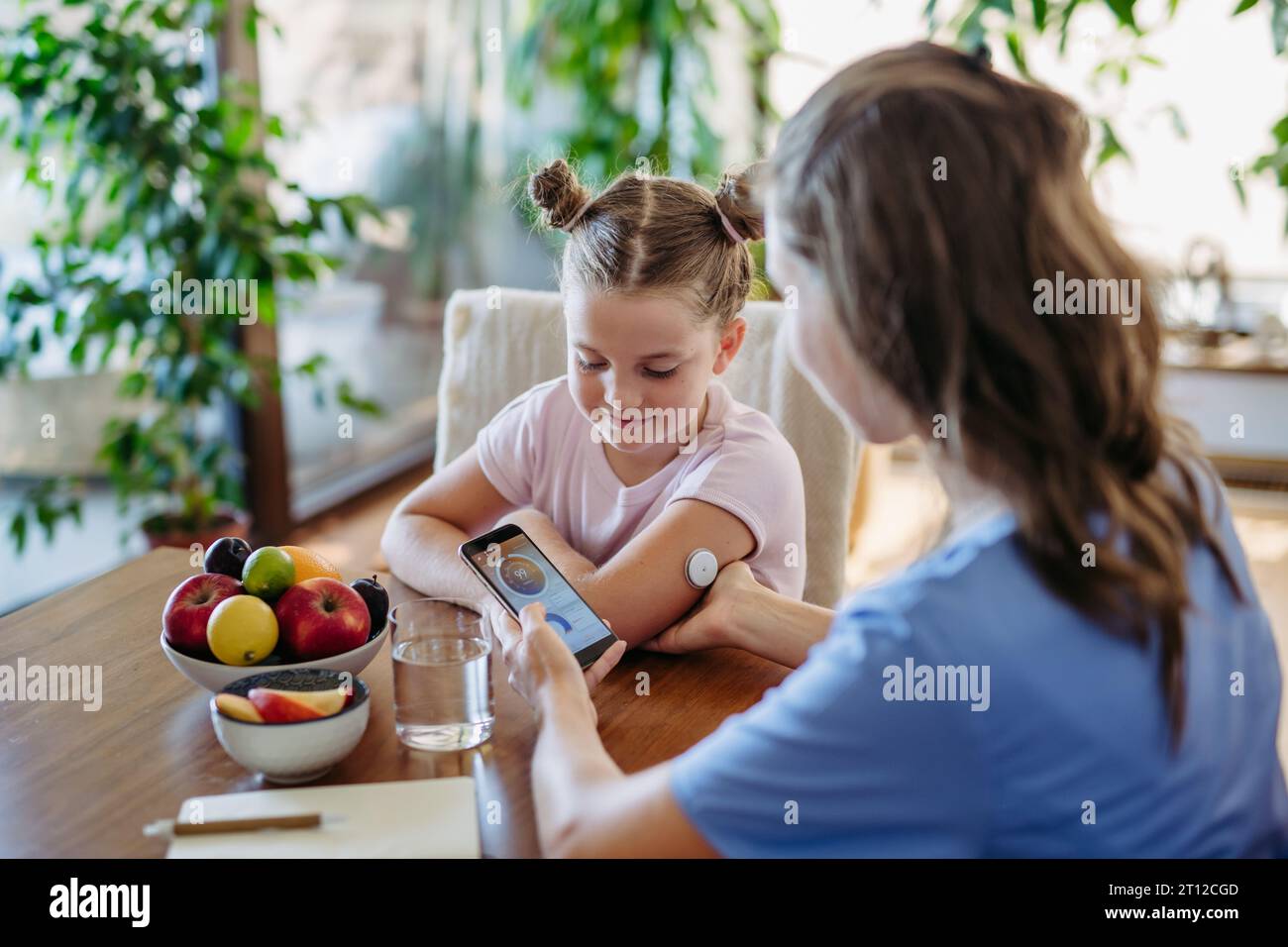 Girl with diabetes checking blood glucose level at home using