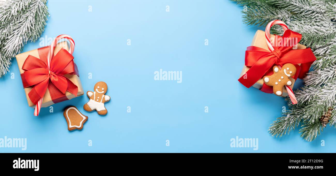 Christmas fir tree branch and gift boxes over blue background with ...