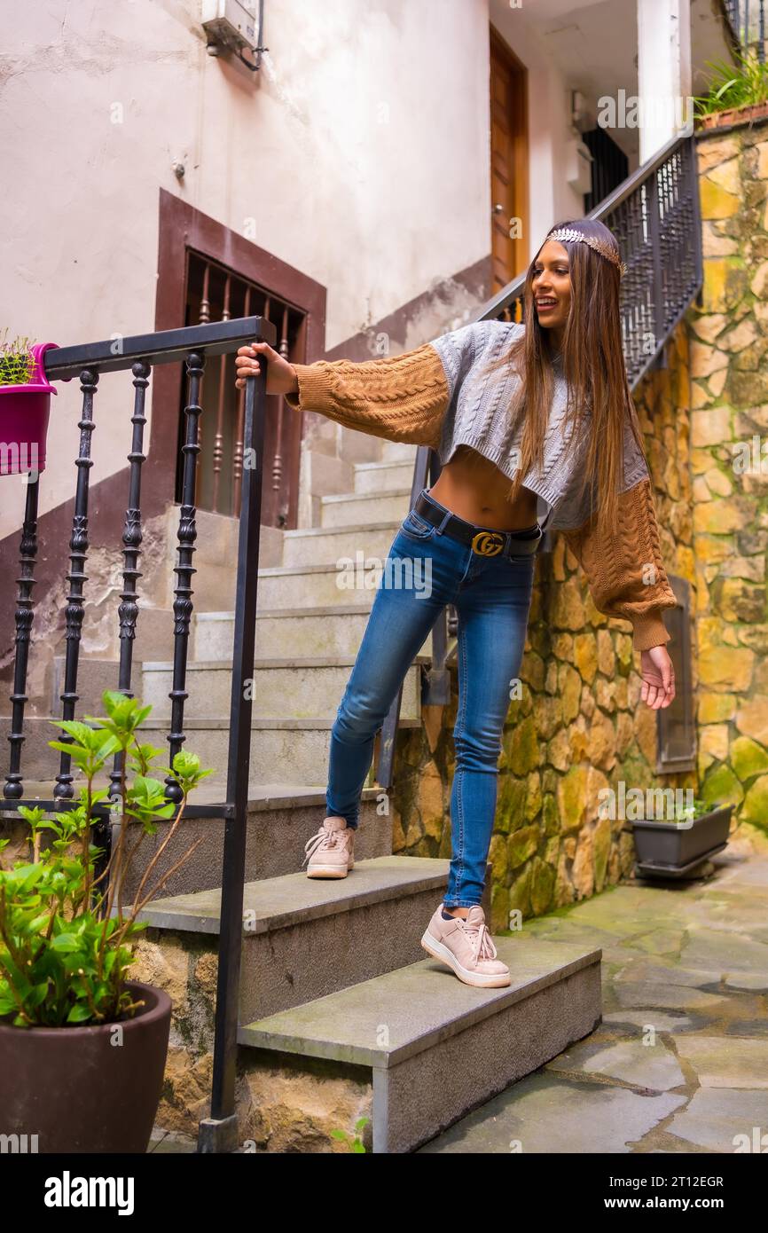 Hipster and hippie girl with a crown on her head enjoying the plants and taking care of them in her house, everyday life in the apartment, on the Stock Photo
