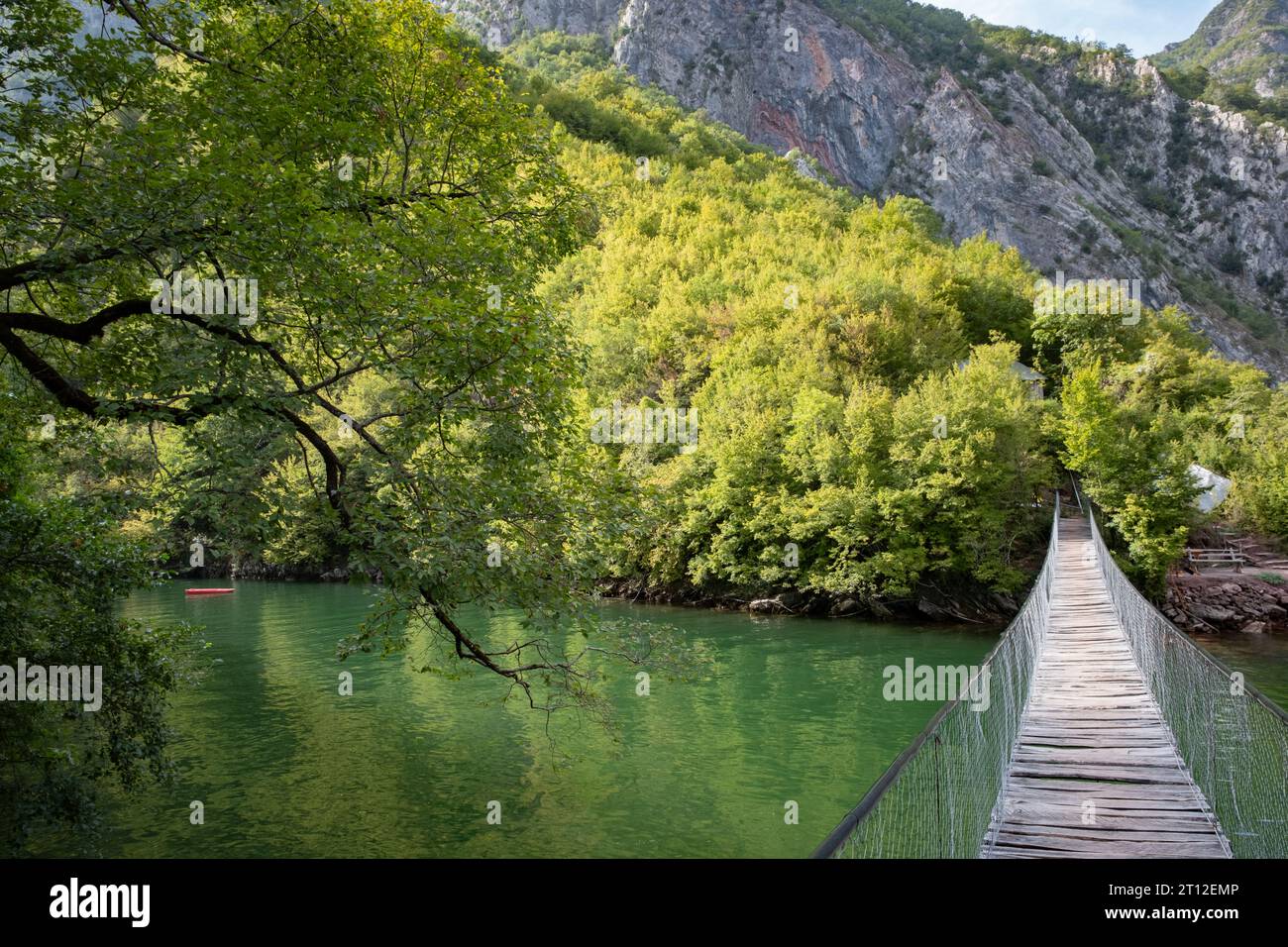 A wooden rope bridge over the water at Lake Komani, Albania Stock Photo
