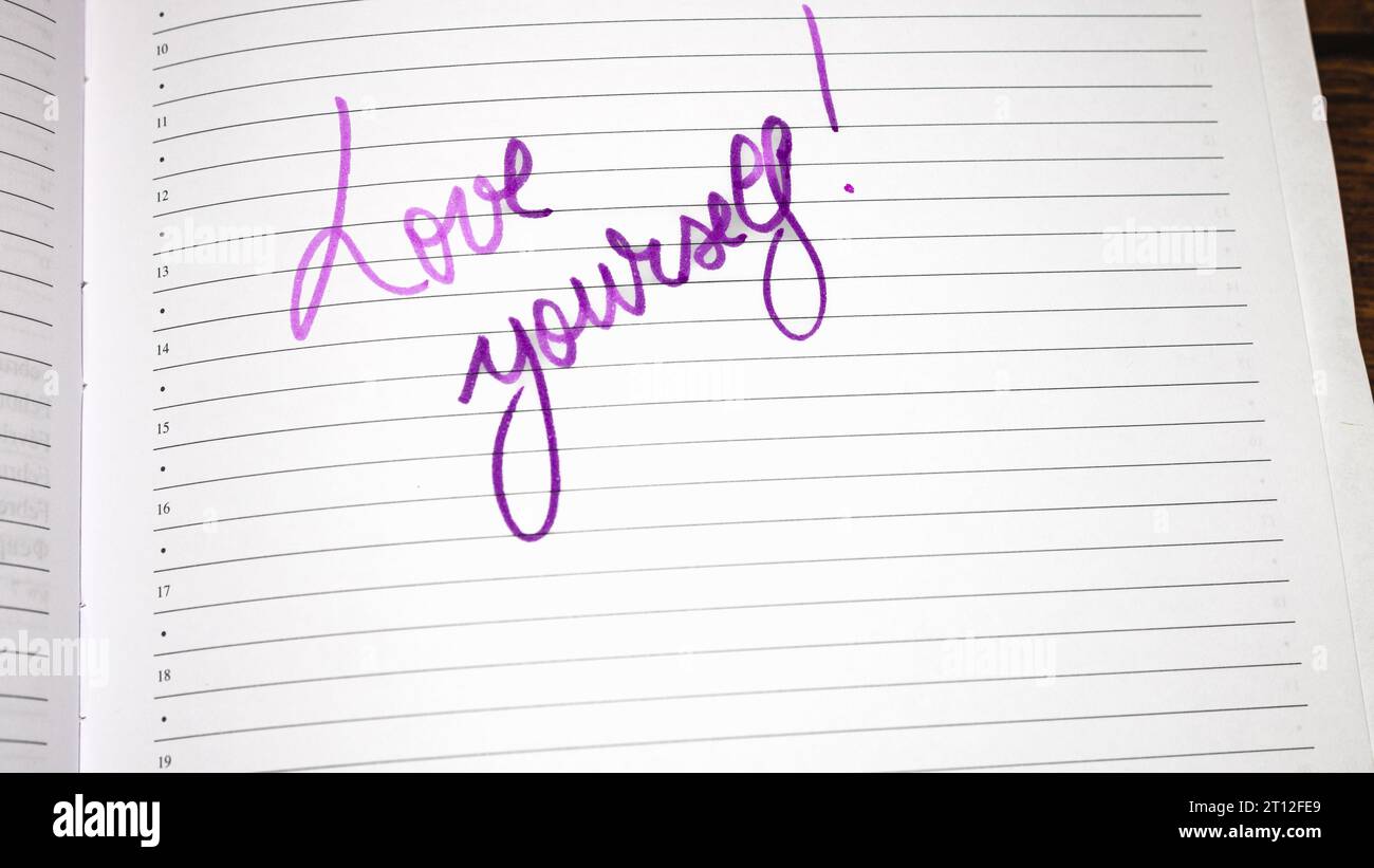 Love yourself, handwriting text on page of office agenda. Copy space. Stock Photo
