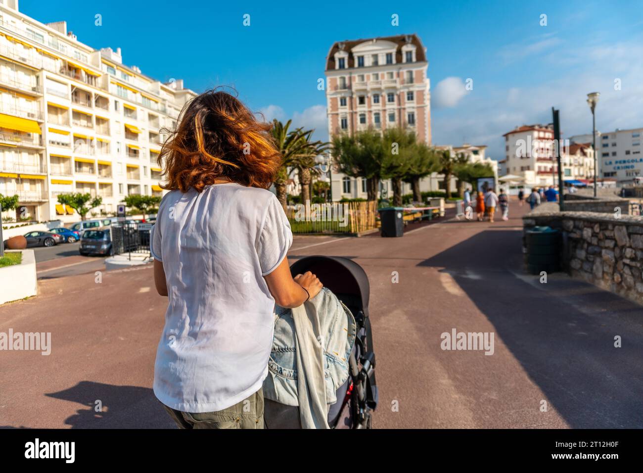 Basque Mother A young mother walking her son in the car in summer on the Grande Plage ...