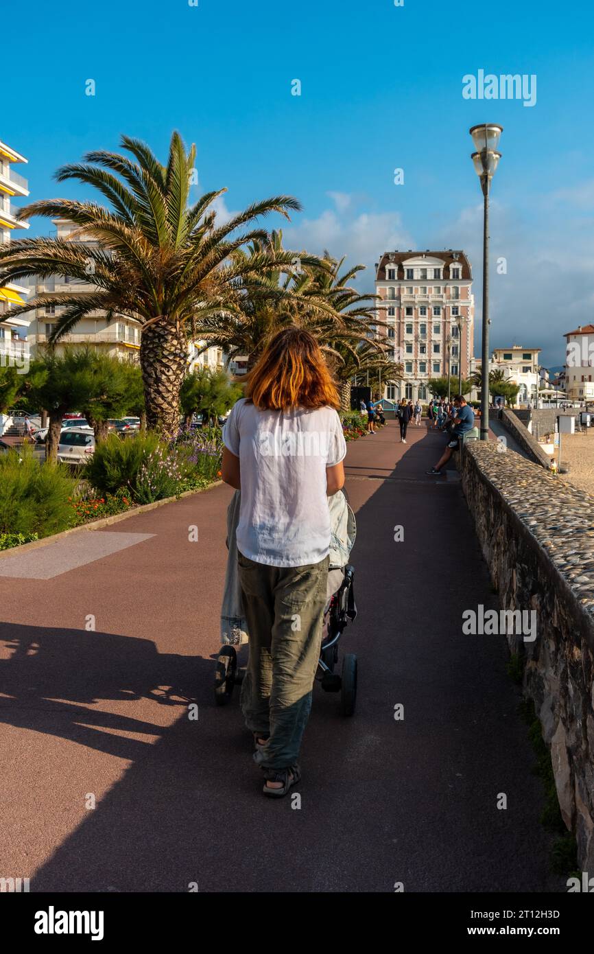 Basque Mother A young mother walking her son in the car in summer on the Grande Plage ...