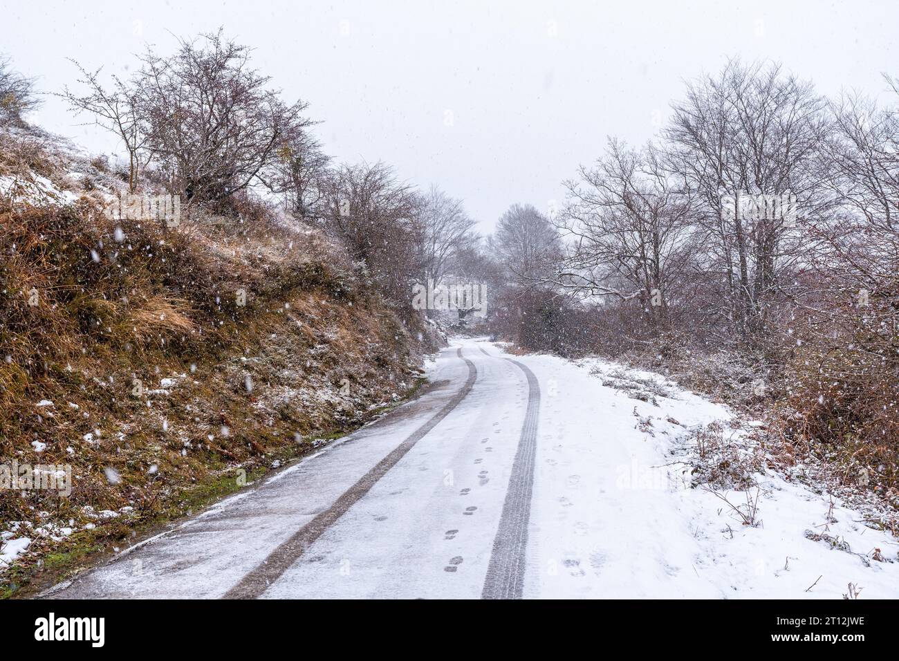 Car tracks on the road to mount aizkorri in gipuzkoa. Snowy landscape by winter snows. Basque Country, Spain Stock Photo